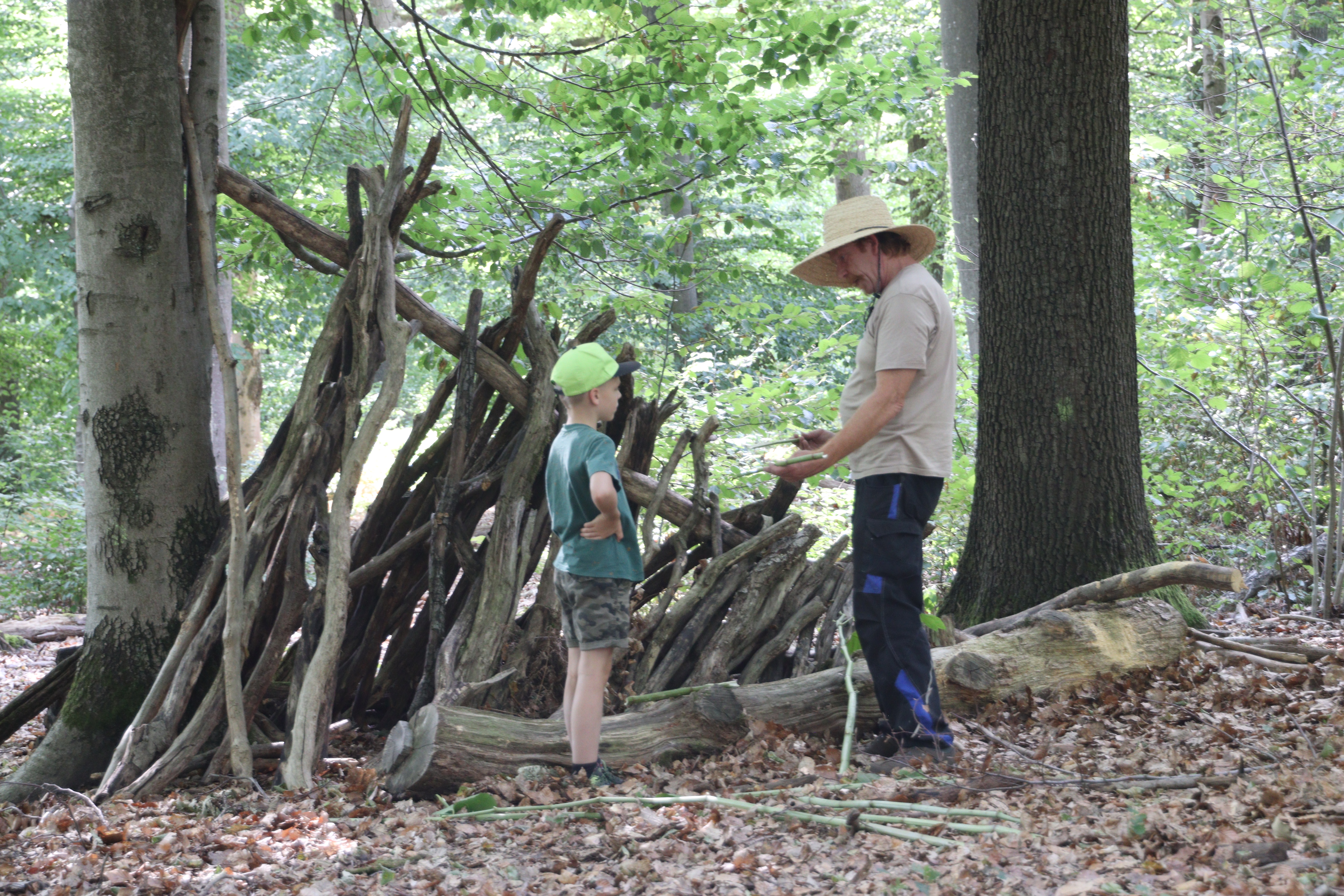 Guido und ein Kind am Bauen im Wald